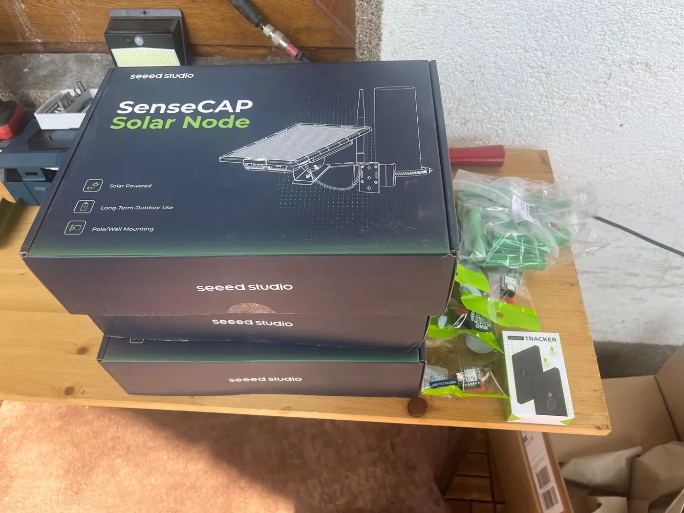 Drei ungeöffnete Kartons Seeed SenseCAP Solar Node, daneben Antennen und Zubehör aus der Sponsoring-Lieferung