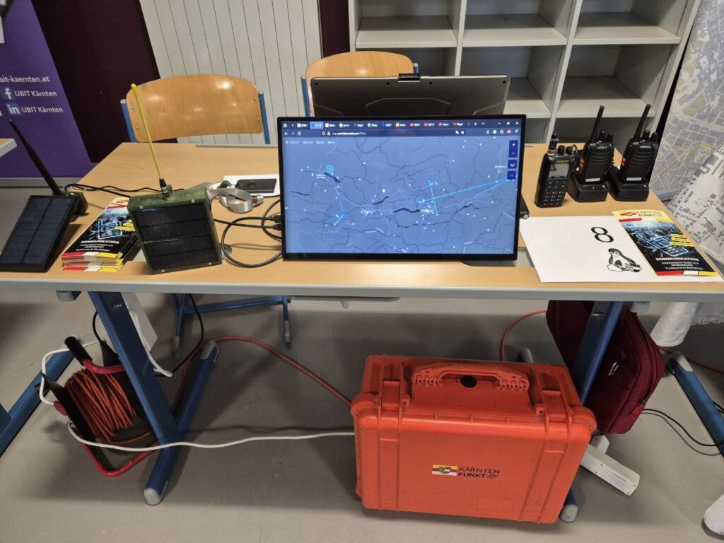 Unser Stand beim Kärntner Linuxtåg mit MeshCore-Nodes, Solarpanelen, Funkgeräten und der Live-Karte vom CarinthiaMesh